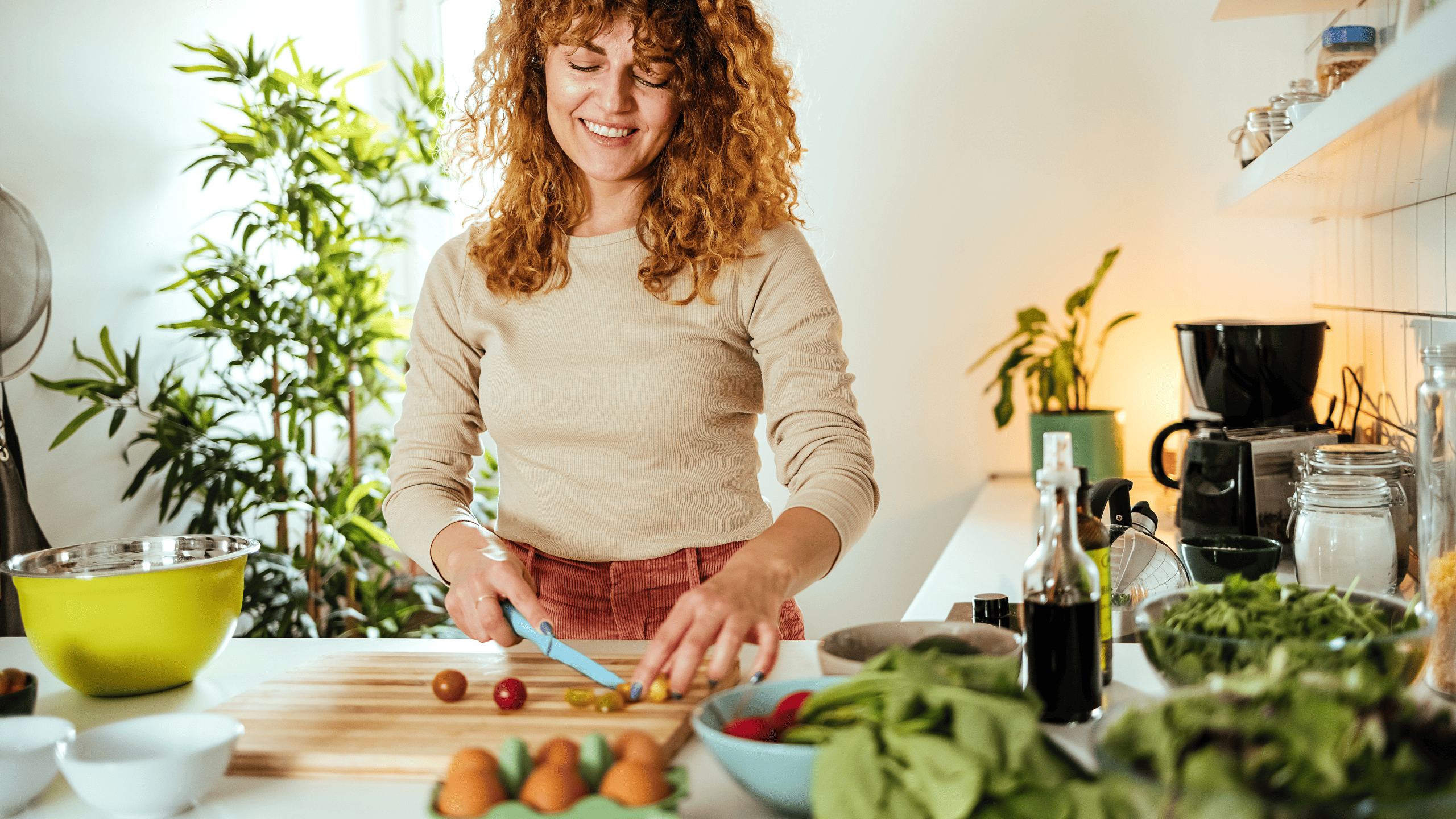Frau bereitet frische Lebensmittel in ihrer Küche zu – zeigt den Erfolg einer individuellen Ernährungsberatung im Vergleich zur Krankenkasse