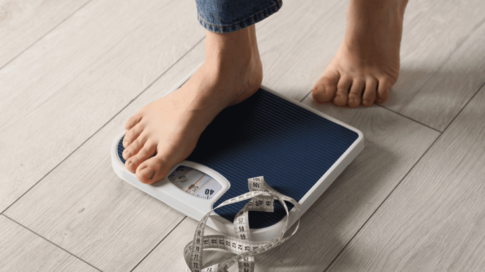Frau steht auf einer Waage und überprüft ihr Gewicht – typische Situation, wenn Veränderungen durch die Pille vermutet werden.