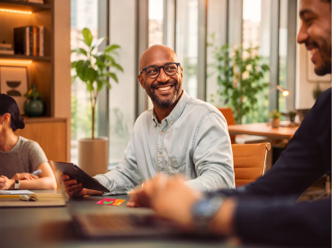 Colaborador sorrindo durante uma reunião no escritório