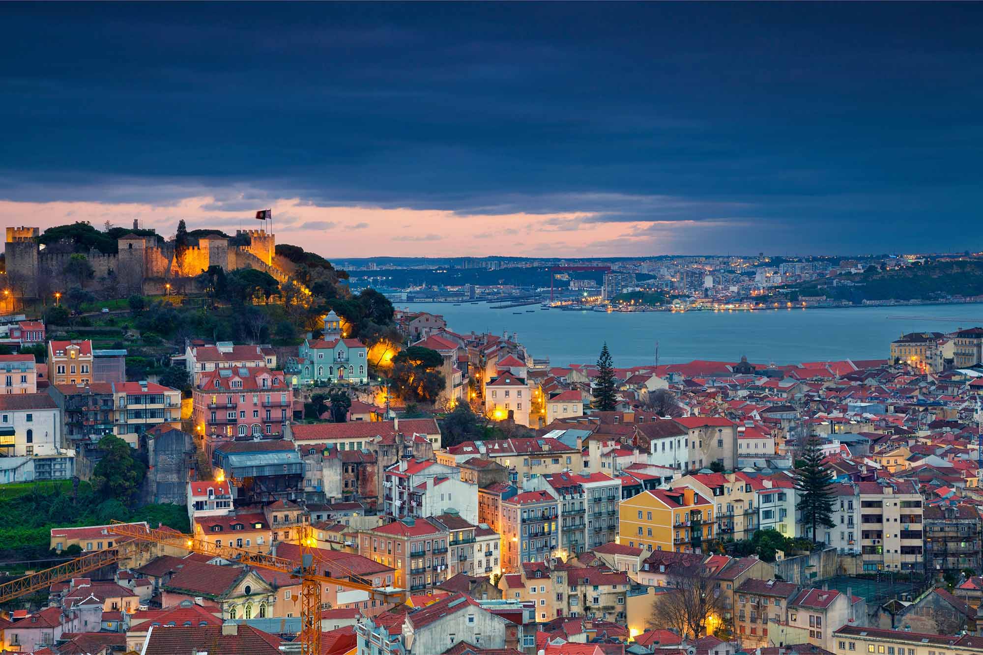 Night-time panorama of Castle of São Jorge overlooking the city of Lisbon and Tagus River