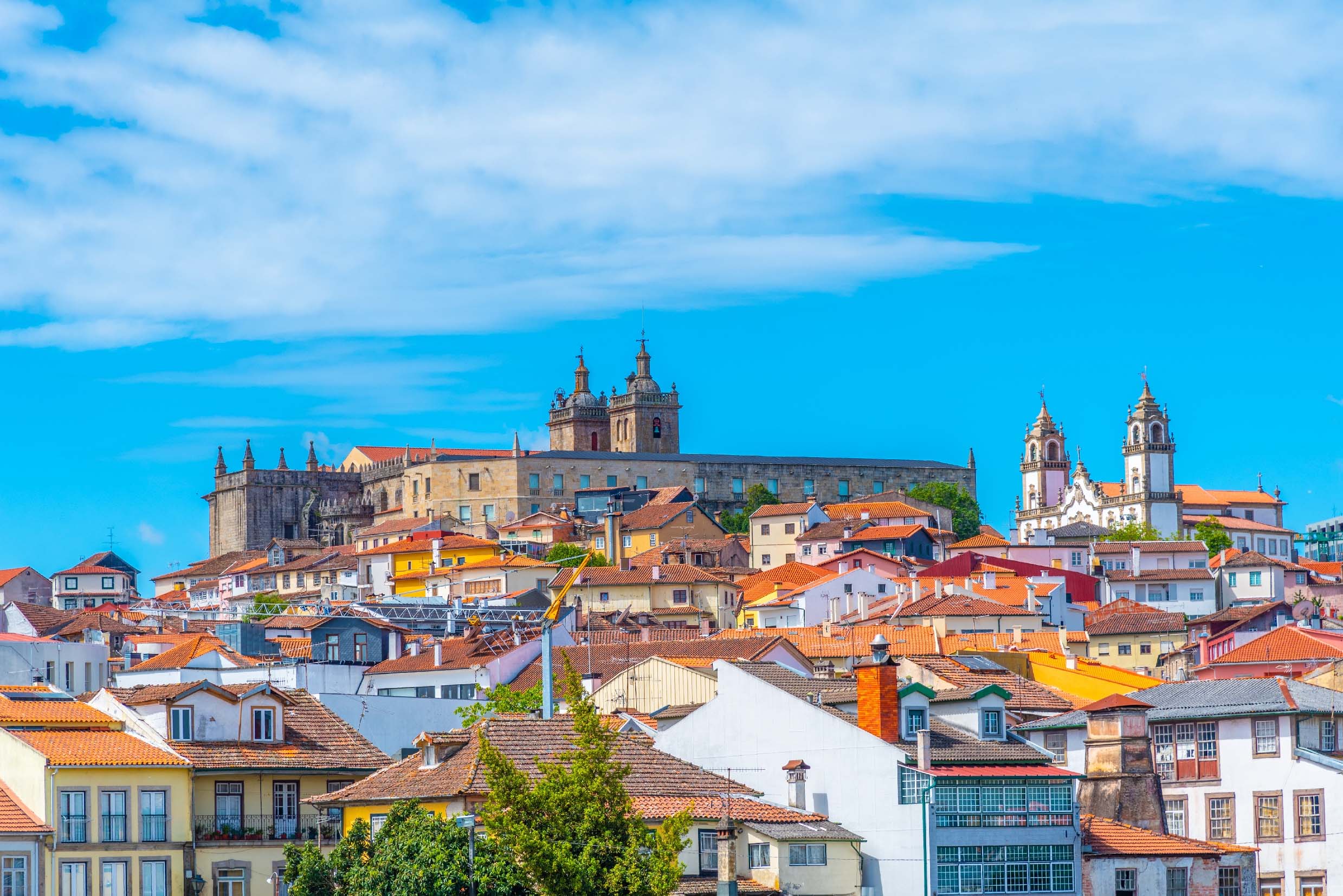 Landmark Viseu Cathedral overlooking the town's red-tiled rooftops, pastel homes and twin-towered church
