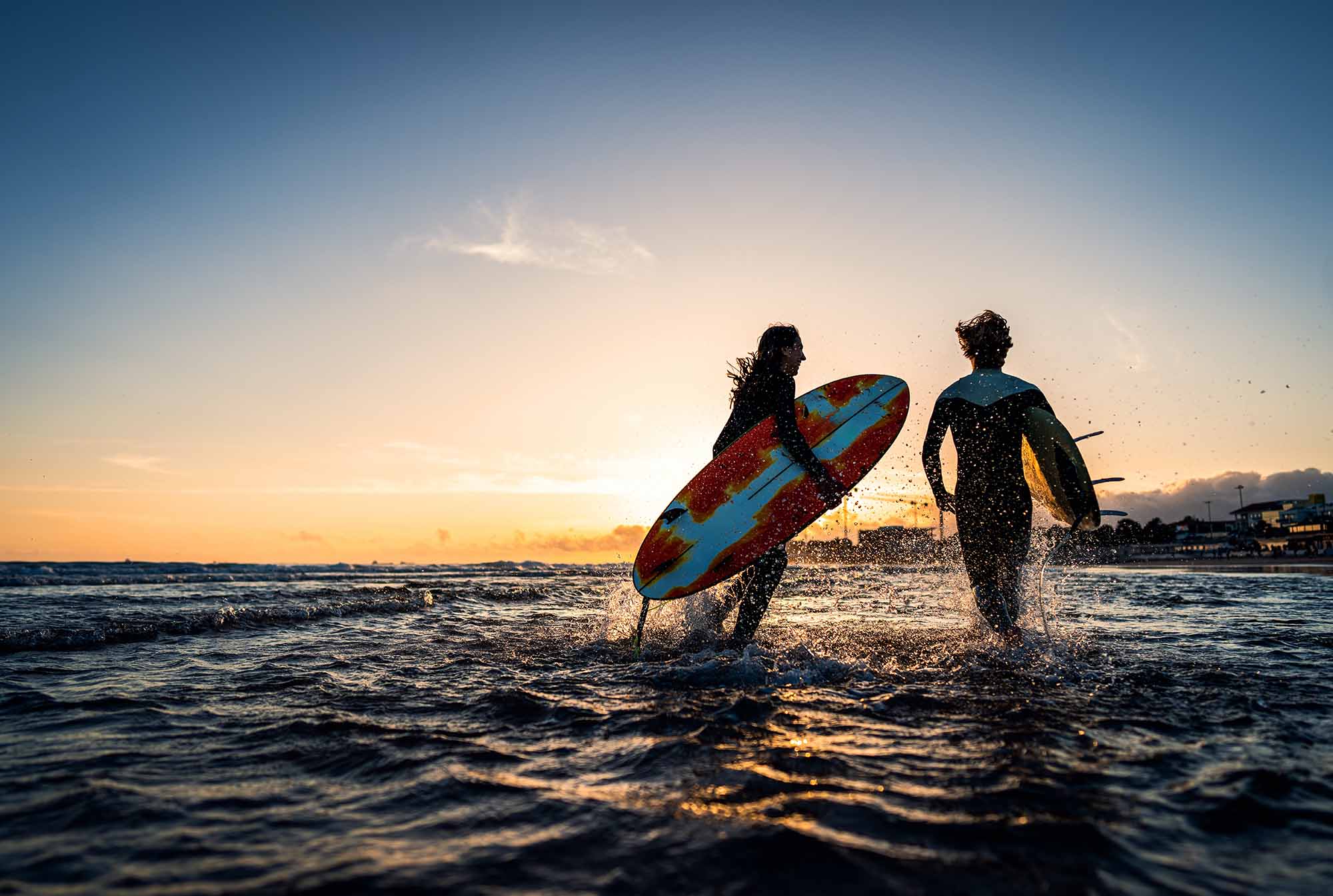Two surfers in the sea on a beach in Portugal