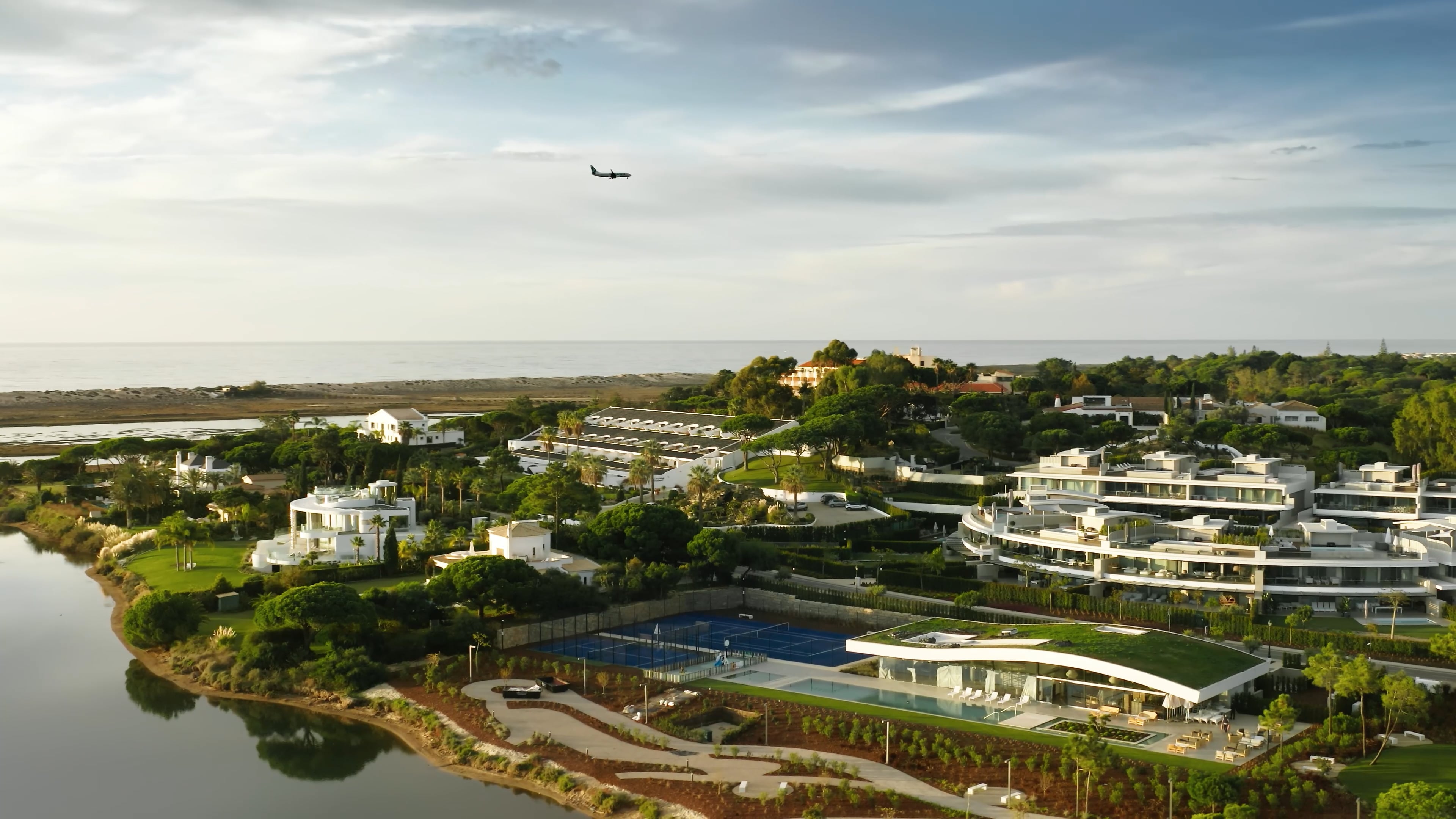 Aerial over a modern resort in the Algarve with an airplane in the background