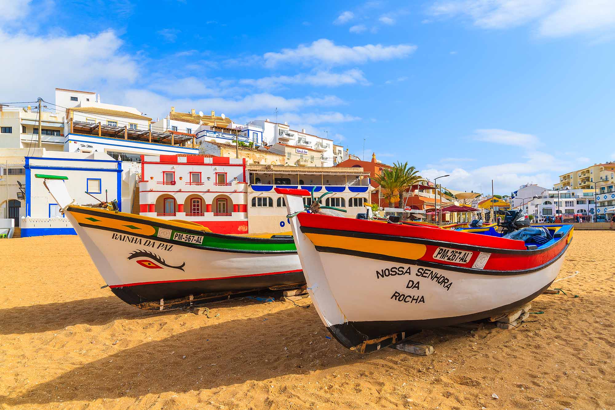 Colorful typical fishing boats on beach in Carvoeiro town, Portugal.