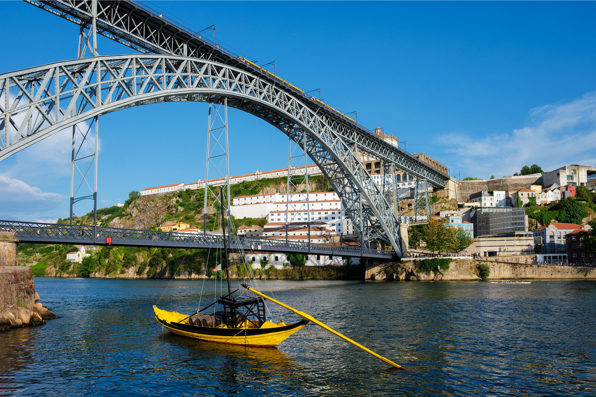 Traditional boat on the Douro river next to the Dom Luis iron bridge
