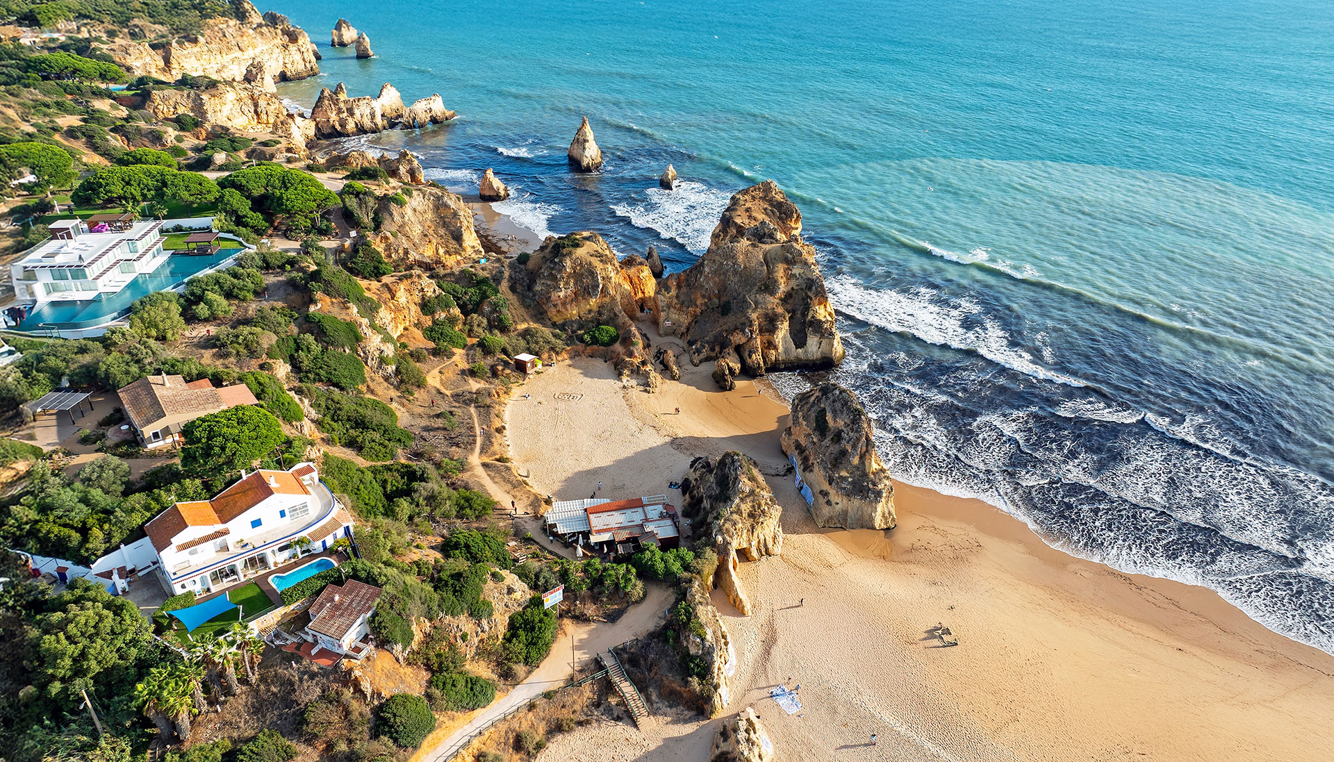 Aerial view of Alvor beach and luxury villas with coastal views