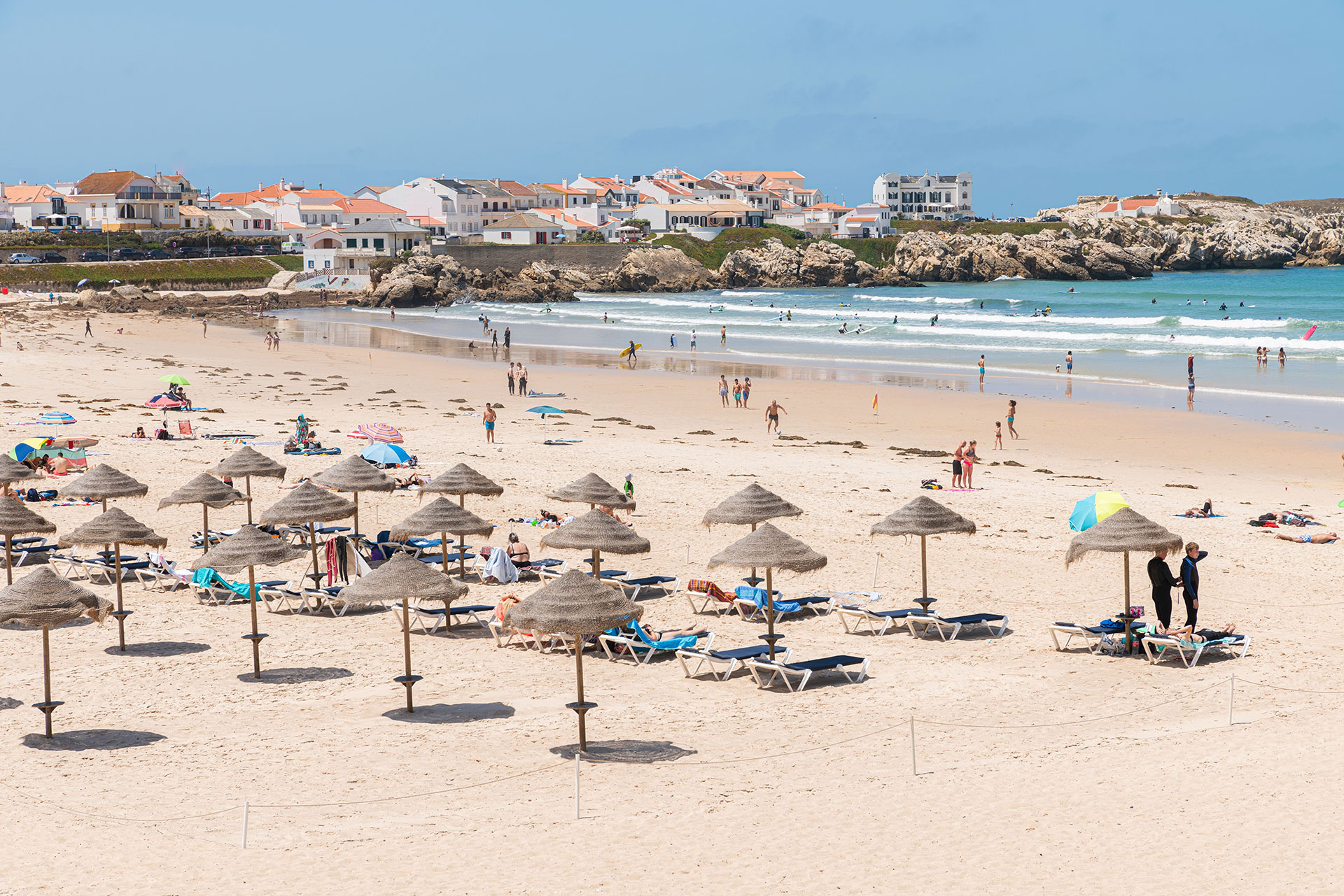 Beautiful Baleal beach decked out with umbrellas and wooden lounge chairs