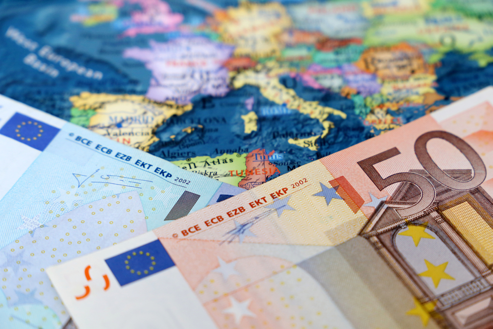 Euro banknotes laid over a map of Europe highlight shared currency and economic integration