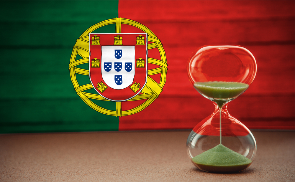 A red hourglass with green sand set against the national flag of Portugal