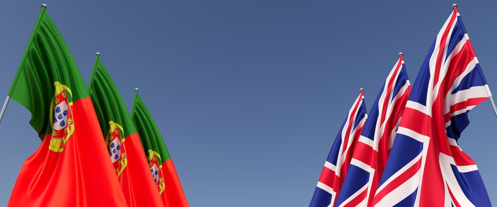 Portugal flags and Great Britain flags with a blue sky background