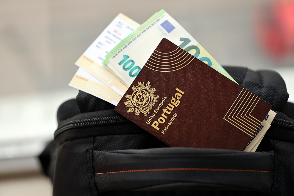 Portuguese passport, TAP boarding passes and €100 notes tucked in sleek black travel bag