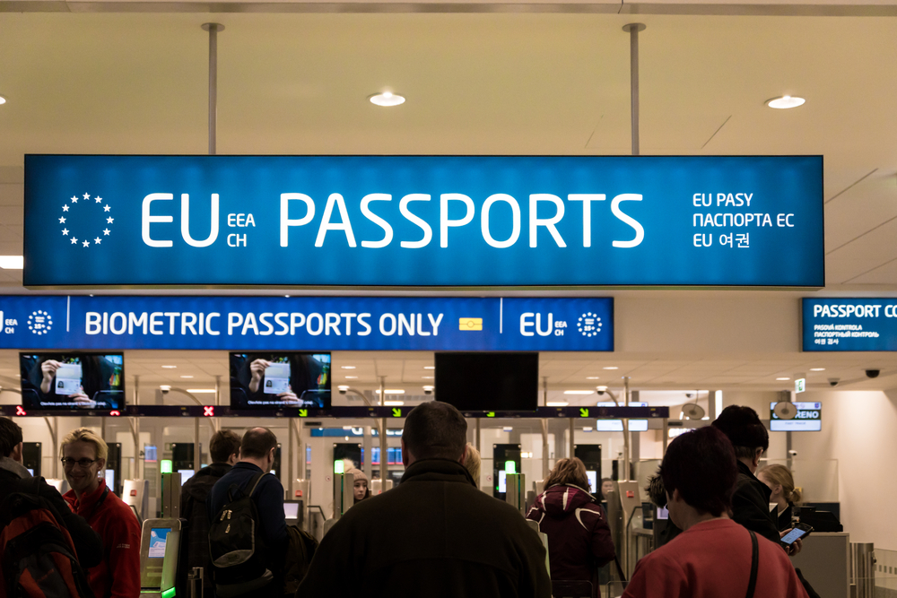Large blue sign for EU passports and biometric documents at an airport immigration checkpoint
