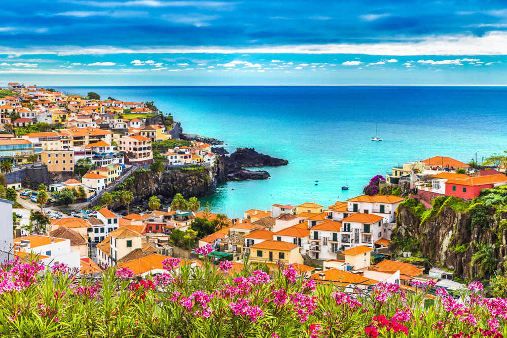 Colorful coastal town of Câmara de Lobos with terracotta roofs and a turquoise bay in Madeira