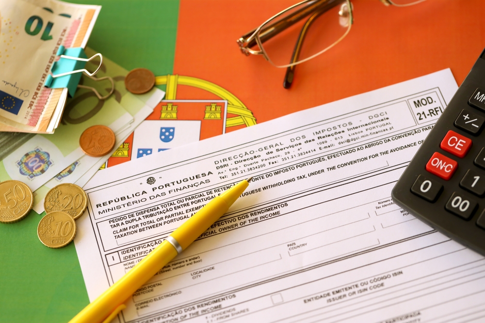 Portuguese tax form with Euro money, a calculator laying on Portuguese flag