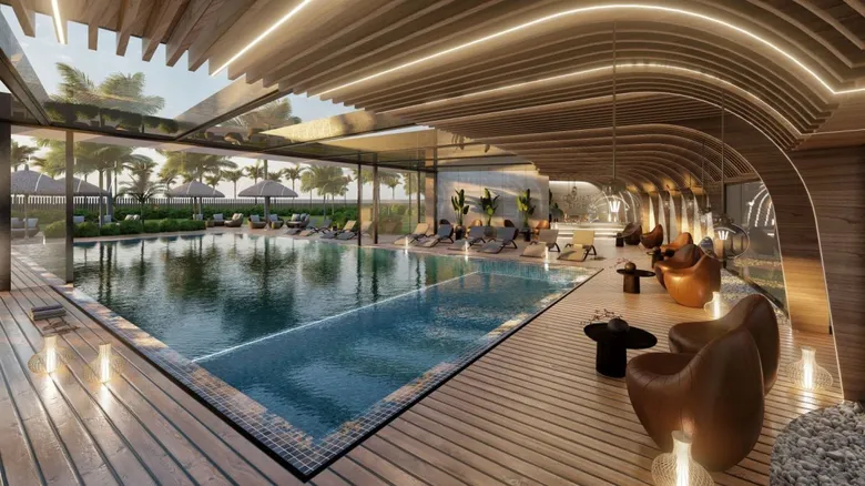 Luxury indoor pool with warm wood ceilings and modern lounge chairs