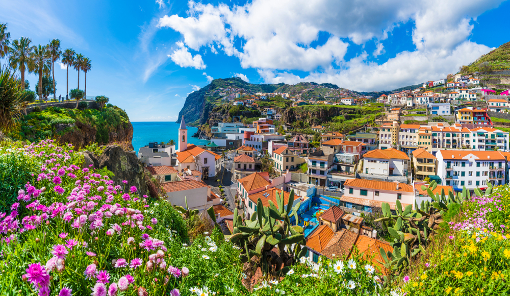 Colorful traditional white buildings on the hillside in Câmara de Lobos fishing village Madeira
