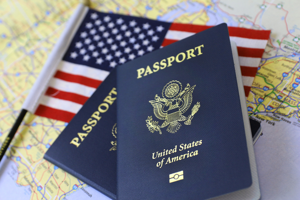 Two US passports and an American flag on a map of the United States