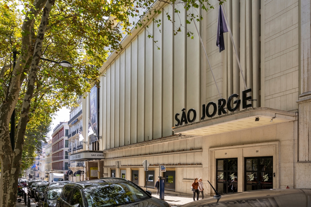 Exterior view of the historic Cinema São Jorge building on a tree-lined street in Lisbon