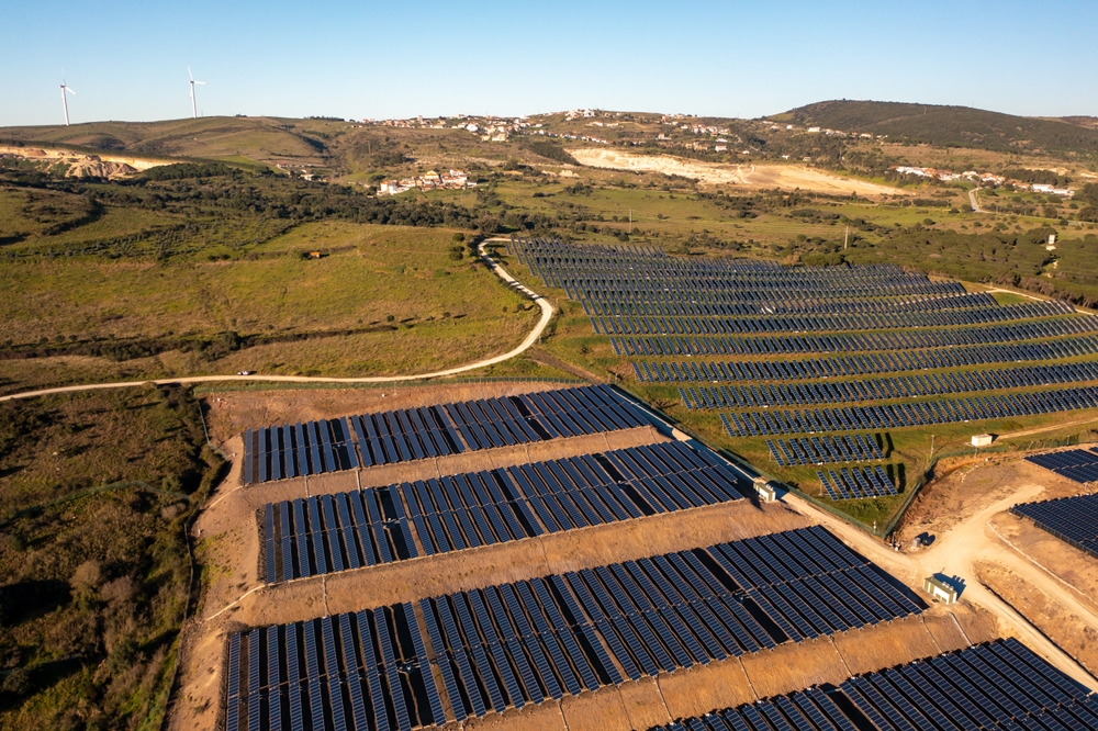 Long rows of photovoltaic panels at solar farm for converting energy of sun to electricity