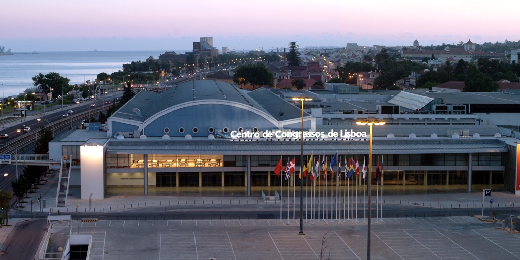 Lisbon Congress Center at dusk with international flags and coastal views