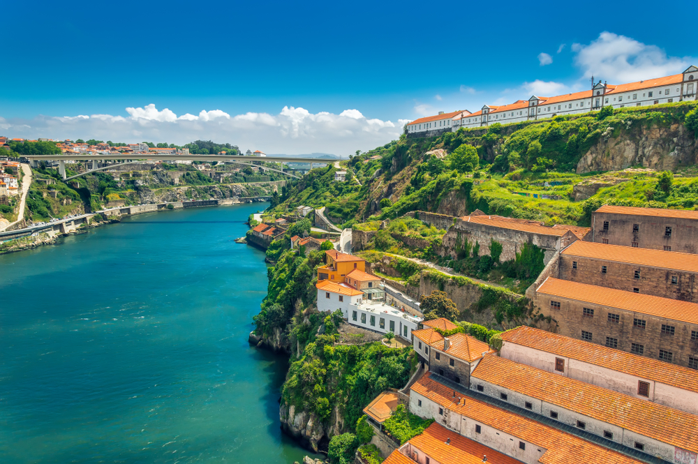 Historic orange-roofed buildings on a steep cliffside overlooking the Douro River