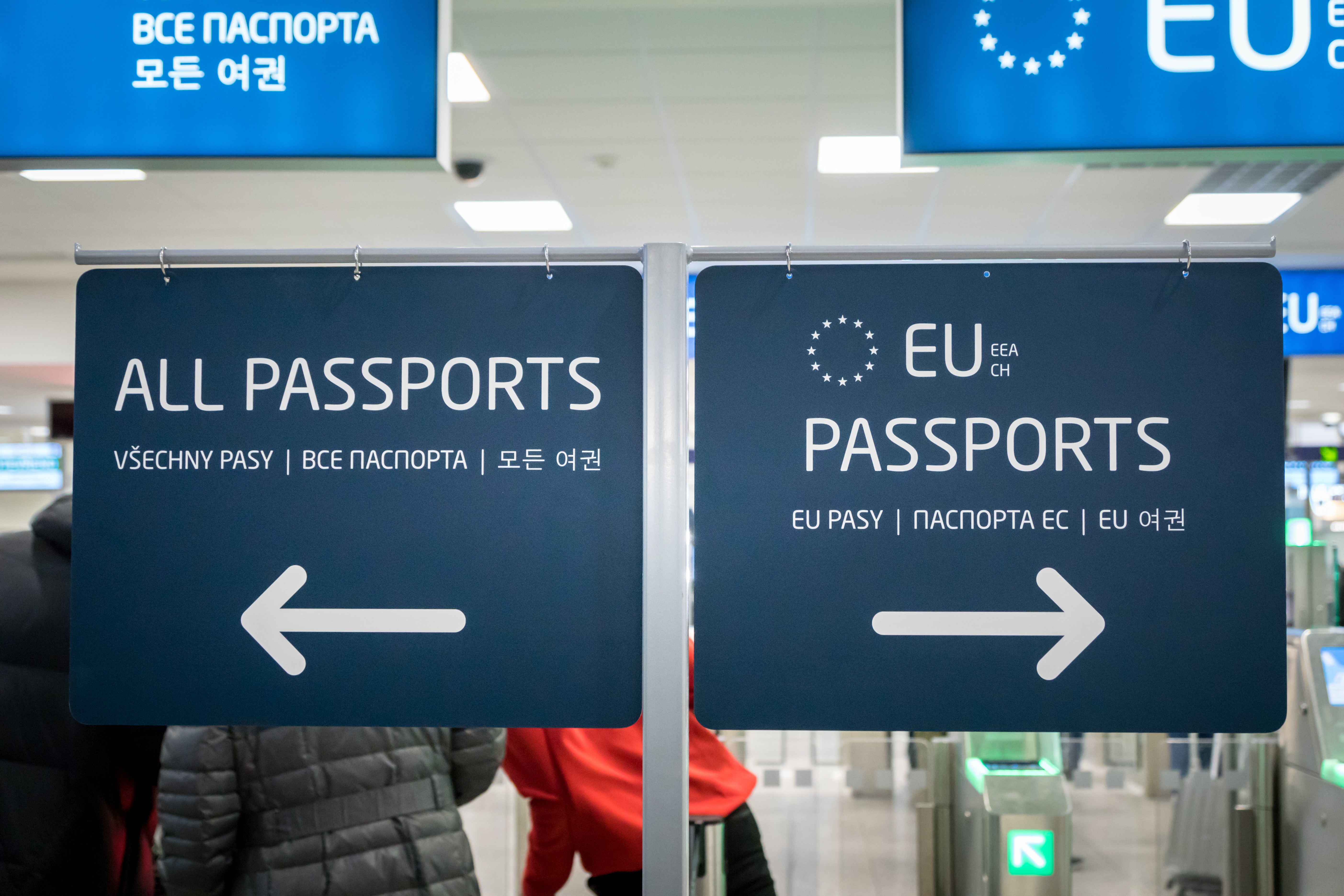 Airport signs directing All Passports to the left and EU Passports to the right.