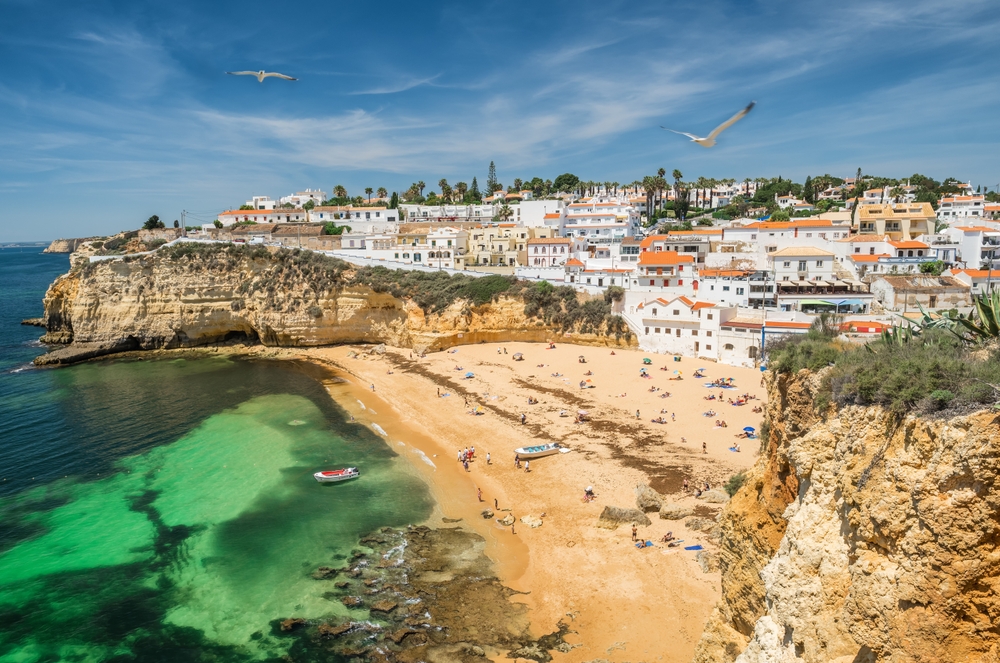 Aerial view of Carvoeiro fishing village with beautiful beach and colorful houses in distance