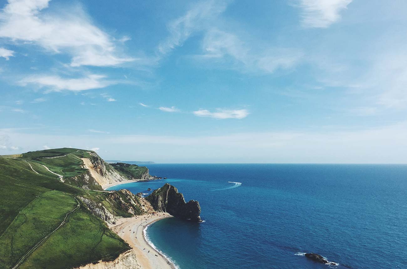 Aerial view of an iconic natural stone arch landmark on a scenic cliff-lined coast