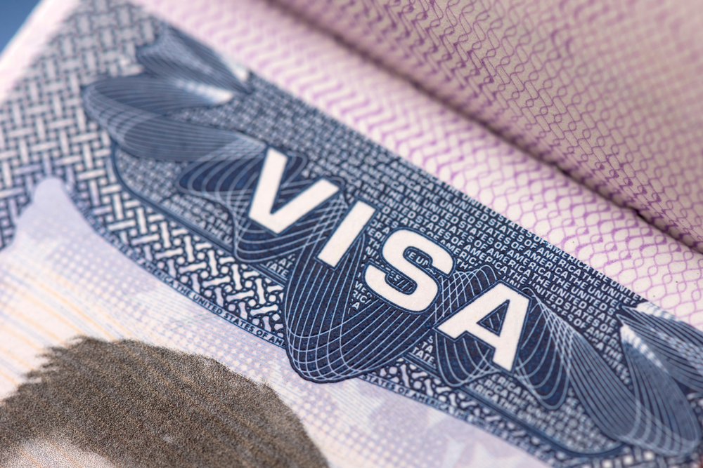 Close-up of a visa stamp in a passport with the word 'VISA' prominently displayed