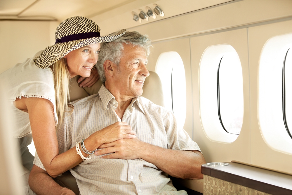Older couple in airplane cabin looking out window
