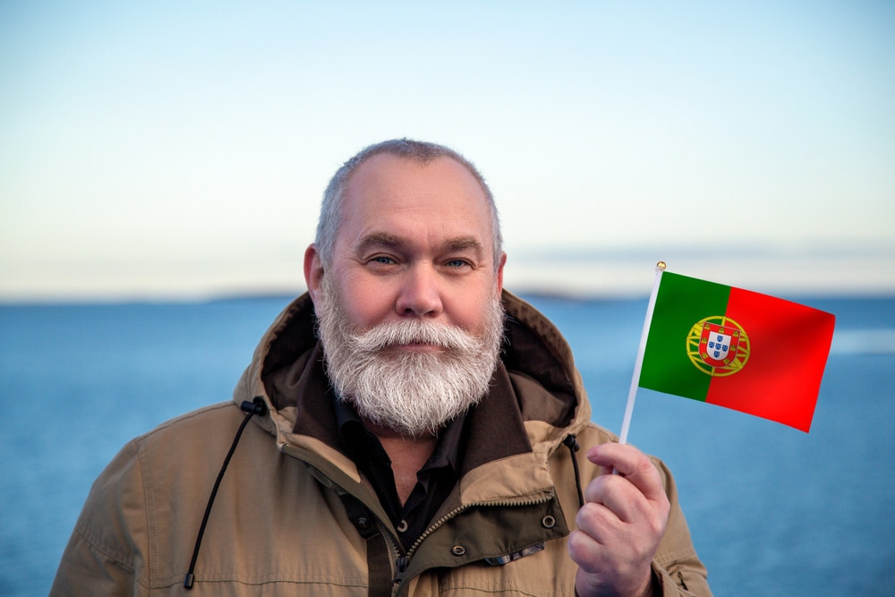 Image of older man holding a small Portuguese flag.
