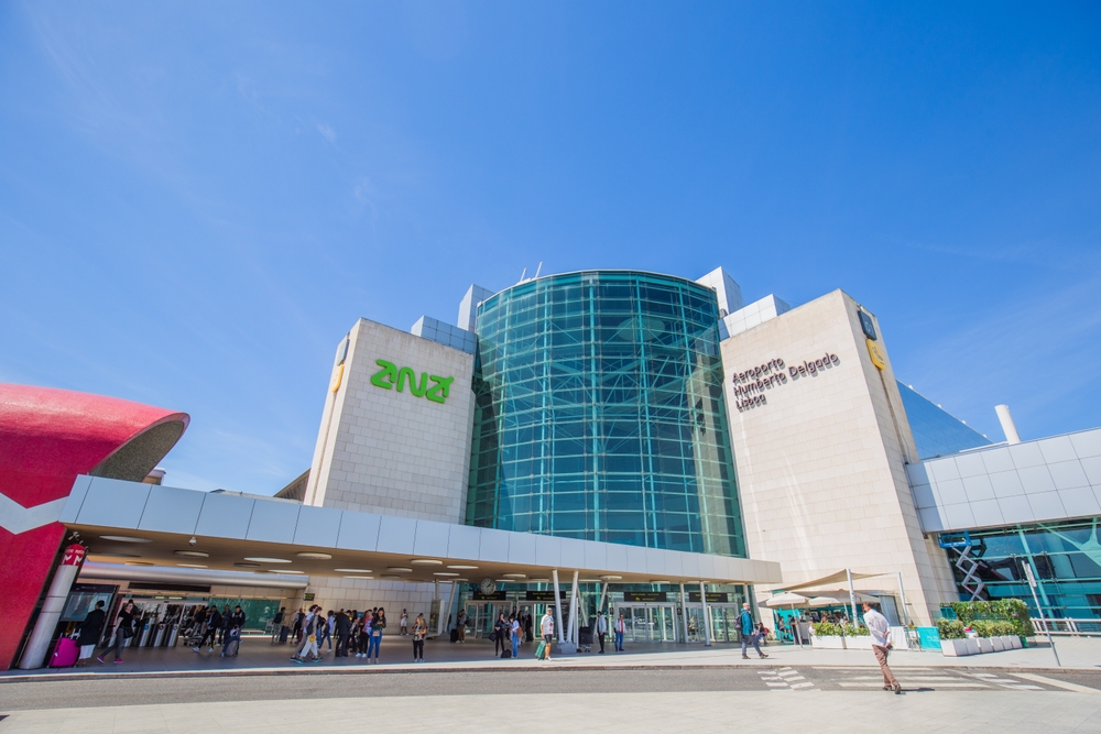 Outside view of the main terminal of Lisbon Airport, with passengers entering and leaving.