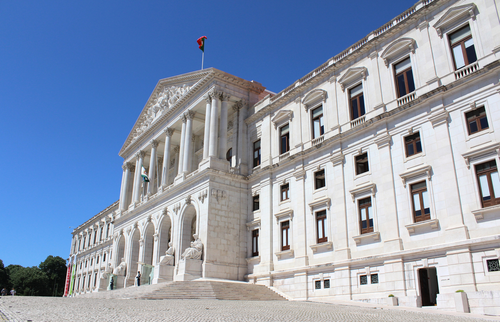 Low-angle side view of the grand São Bento Palace under a clear, bright blue sky