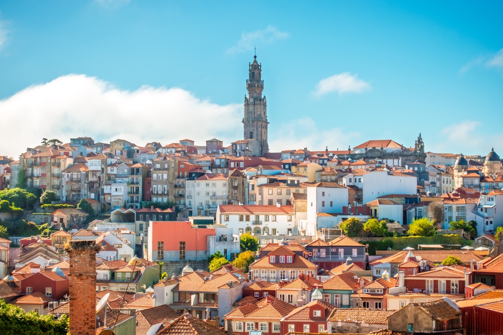 Clerigos Tower rising above the colorful terracotta rooftops of Porto under a blue sky