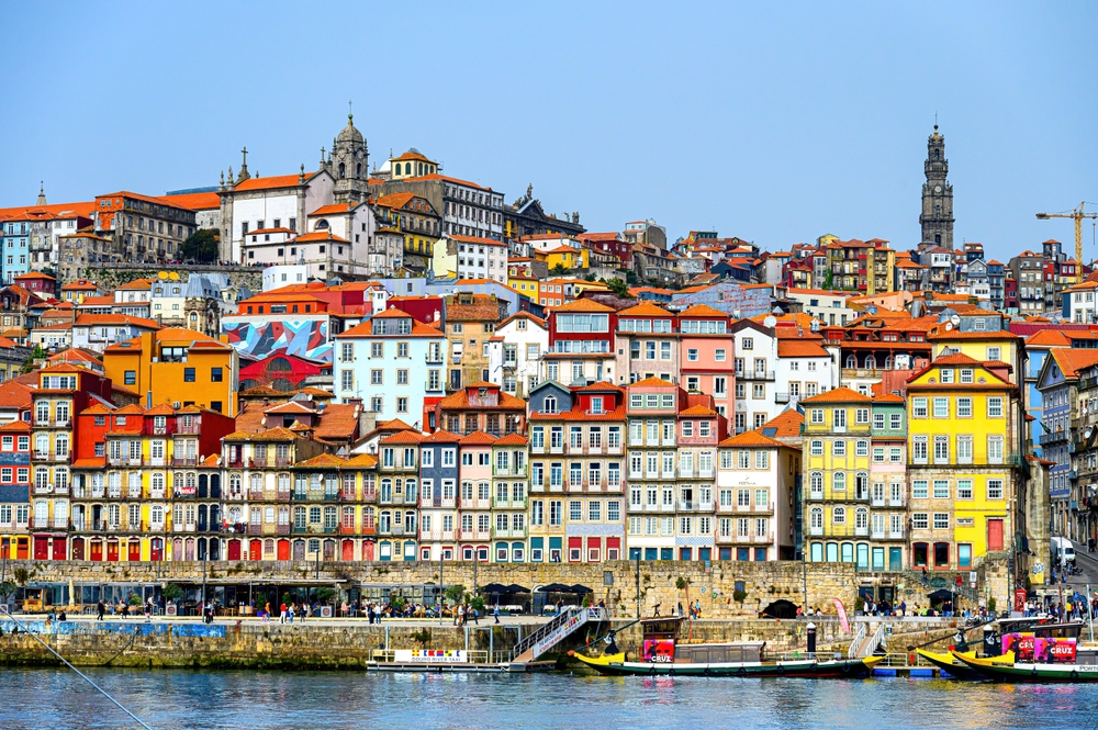 Vibrant Porto Ribeira riverfront with colorful traditional houses and rabelo boats on the water