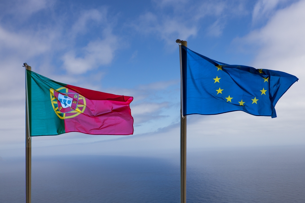 Portugal flag and EU flag with blue sky in the background
