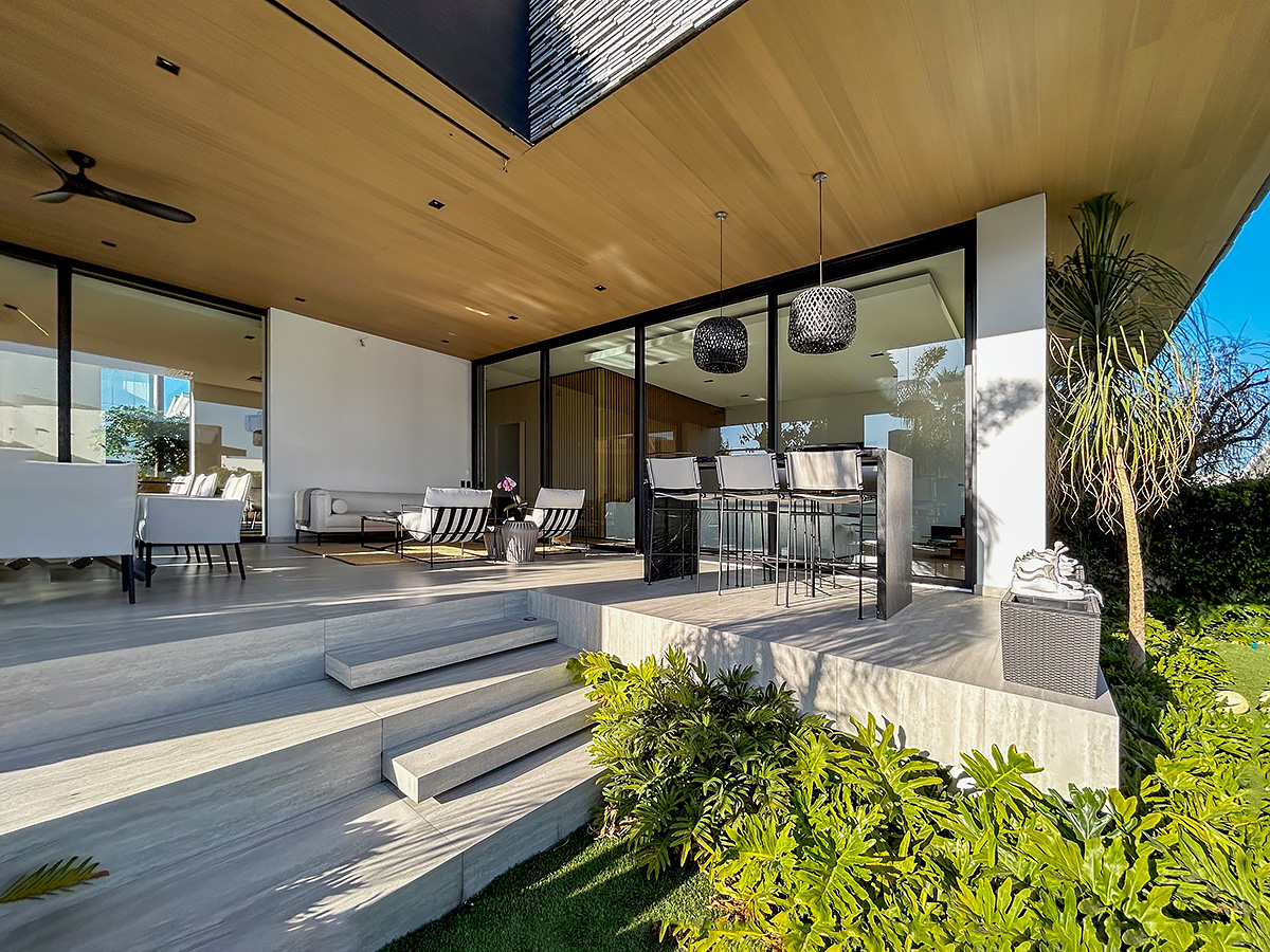 Modern outdoor living area with wood ceiling and designer patio furniture