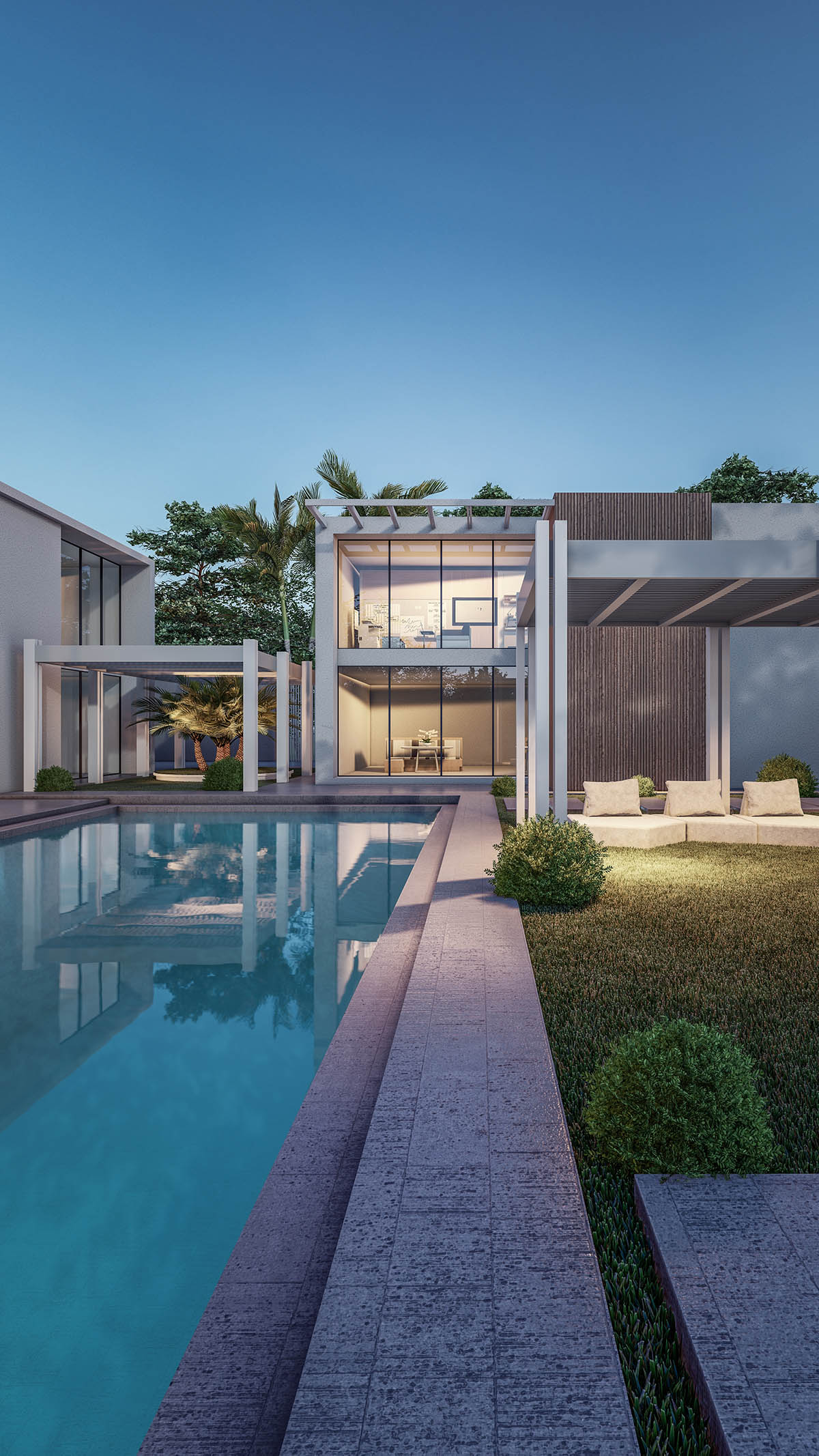 Modern luxury villa with glass walls, swimming pool, and stone patio at dusk