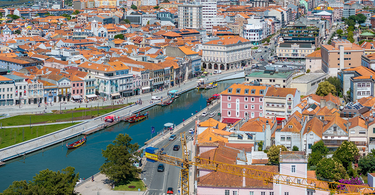 Aerial view of the central canal in Aveiro, Portugal, with moliceiro boats and city skyline