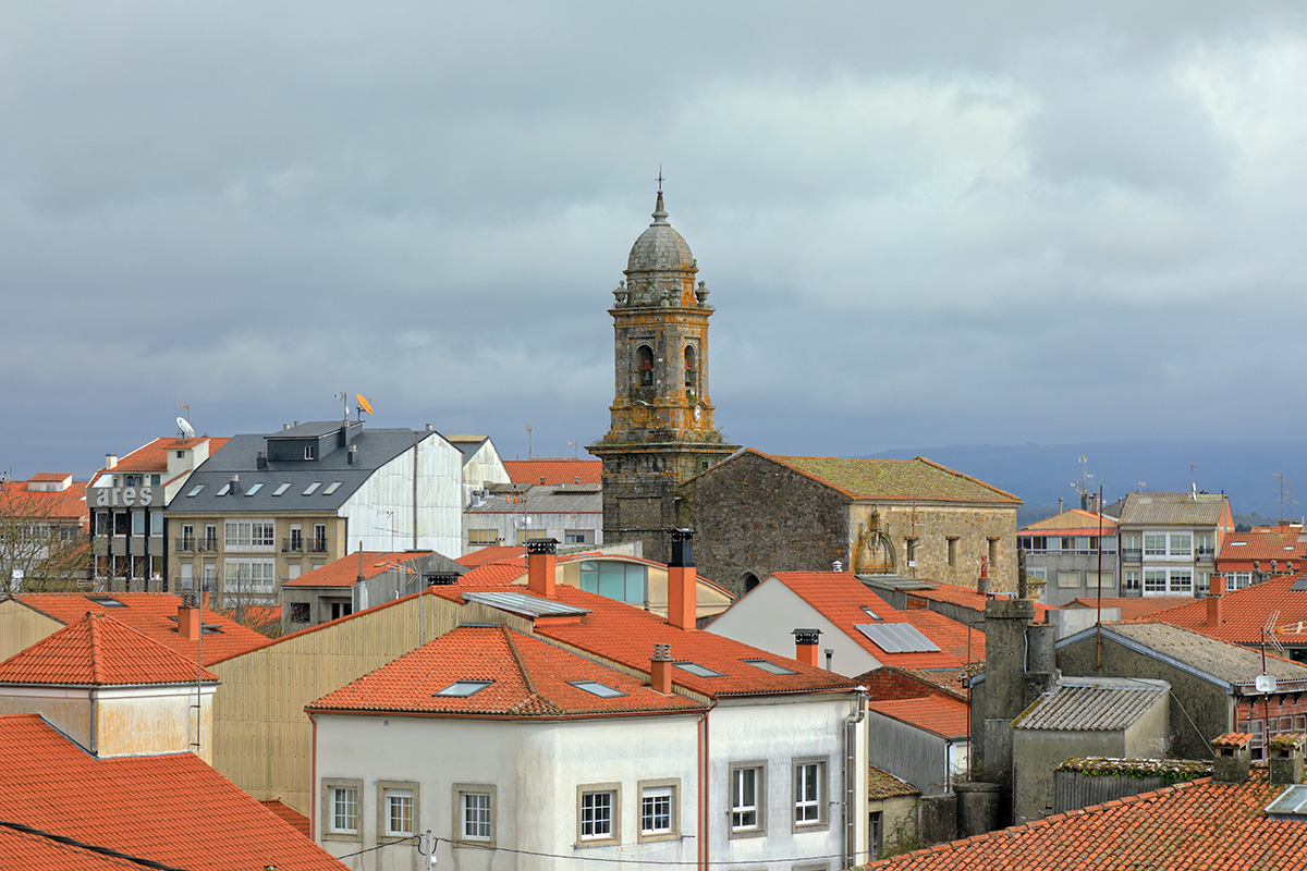 Traditional red-tiled rooftops and a historic church bell tower in the town of Melides