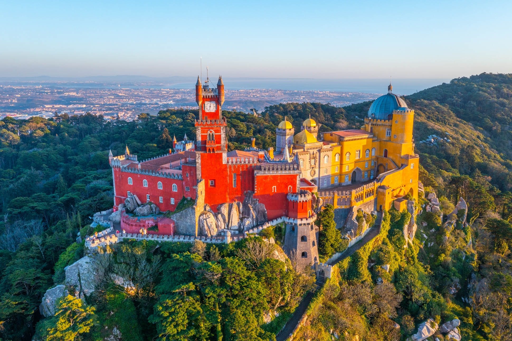 Aerial view of the colorful Pena Palace in Sintra, Portugal, nestled in lush green hills