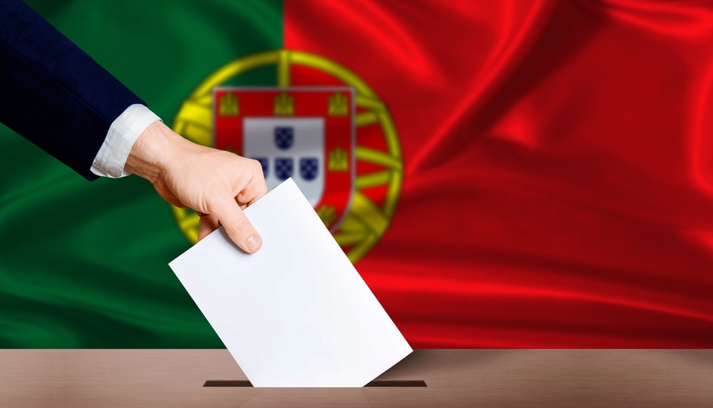 Man casting ballot with Portugal flag in the bcakground
