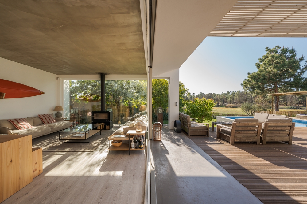 Interior of modern house in Portugal with view outside to large garden and swimming pool