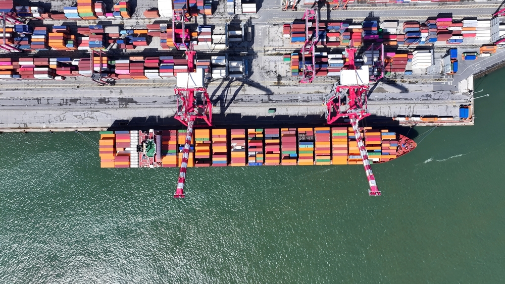 Aerial view of boat with shipping containers at a port in Portugal