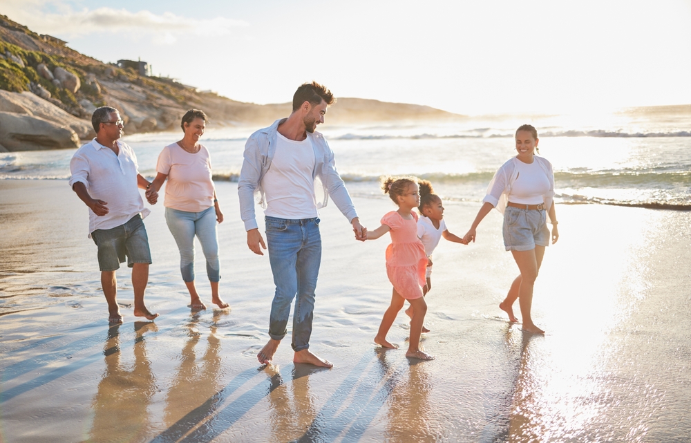 Happy family walking along beach in Portugal