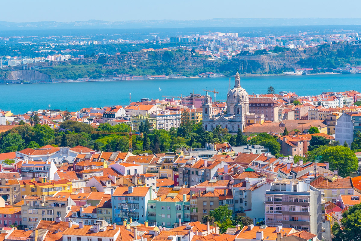 Aerial view of Lisbon's colorful red-roofed buildings and the Tagus River in Portugal