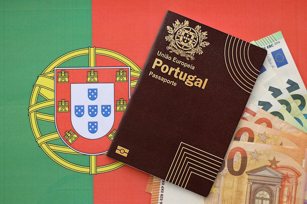 Portugal passport and euro notes on Portugal flag