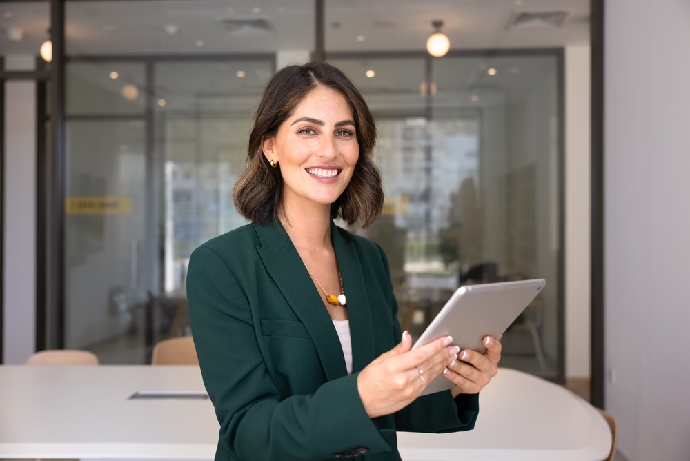 Business woman smiling and holding an iPad