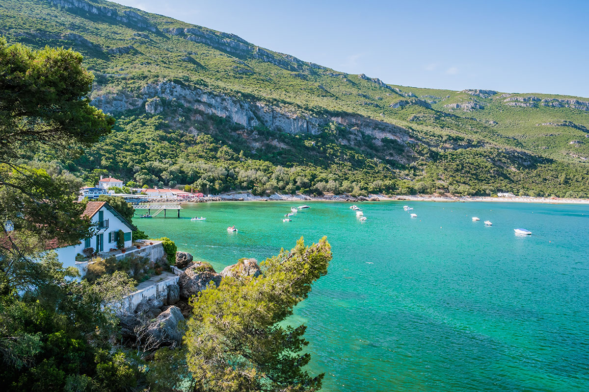 Striking landscape of Portinho da Arrábida beach with mountains in the background