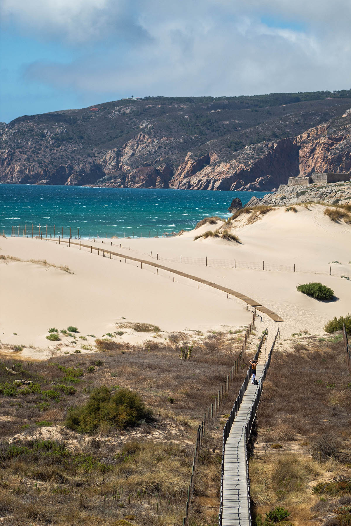 A vertical shot of a bridge leading to Praia do Guincho, Cascais, Portugal